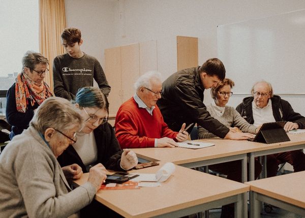 Foto: Schülerinnen und Schüler der Sekundarschule in Winterberg zeigen den Senioren den Umgang mit Smartphone und Tablet. 